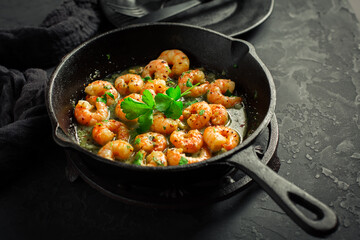 Shrimps with garlic, olive oil and parsley in frypan