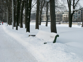 Bod bench with a large snowdrift in the park