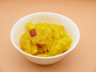 Pickled spicy yellow Korean cabbage with spices in a bowl