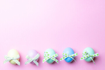 Fototapeta na wymiar Easter egg hunt. Colorful egg with tape ribbon on pastel pink background in Happy Easter decoration. Traditional design in top view.