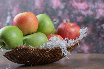 Apples in a wooden basket on a white burlap