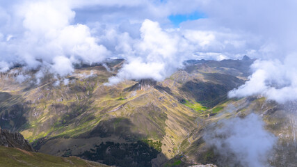 Fototapeta premium view of a finger-shaped hill covered in ice cream-like clouds