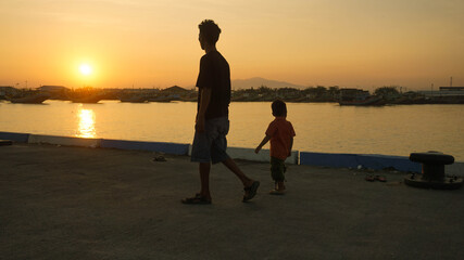 Siluet ayah dan anak di pelabuhan / silhouette of a father and son on the harbour 3