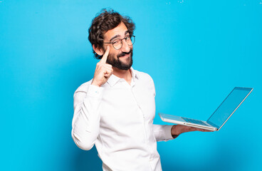 young bearded man holding a laptop