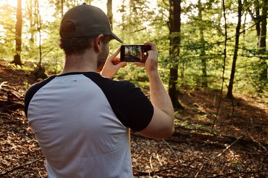 A young man taking a photo with his phone