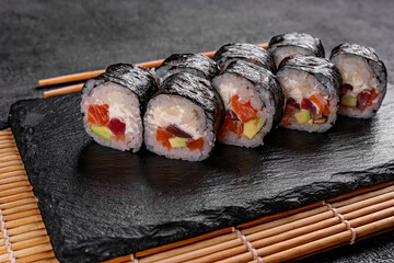 Sushi Rolls with fresh fish and cheese inside. Roll on glass black background. Sushi menu. Japanese food.