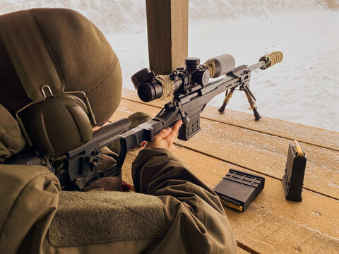 Army sniper looking through the scope. Snipers images. The sniper lies and aims through the telescopic sight. Sniper Rifle with magazine inserted and ready to fire! Position. Training. On the range.
