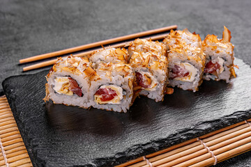 Sushi with salmon, cucumber and caviar. Sprinkle with the shavings of tuna