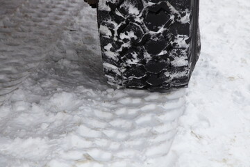 Off-road truck big wheel track on snowy road, 4x4 tyre print on snow close up, vehicle winter driving safety