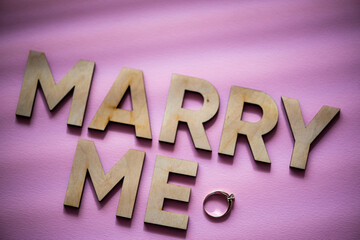 Alphabet letter wooden letters with words Marry me. Marriage proposal and love concept for Valentine`s day with wedding or engagement 