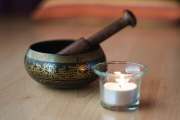Obraz na płótnie Canvas .Tibetan bowl next to a candle on a wooden surface