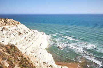 Tourists stroll and sunbathe at the "Scala dei Turchi" (scale of the Turks) located in the province of Agrigento, Sicily