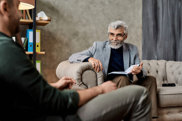 Mature psychotherapist taking notes during appointment in office