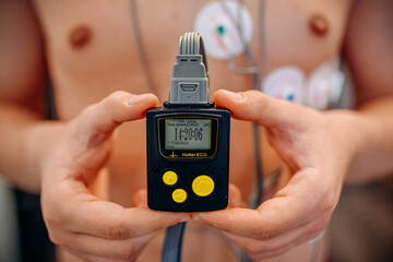 Heart electrocardiogram or monitoring using Holter for young patient. Male athlete does a cardiac stress test. wearing Holter monitor device for daily monitoring of an electrocardiogram. 