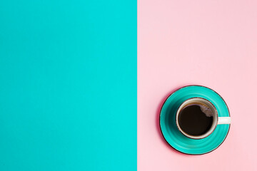 Top view of coffee cup with coffee on blue and pink bright background. Creative concept of advertising banner with copy space.