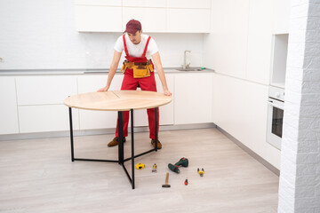 Young man assembling kitchen furniture.