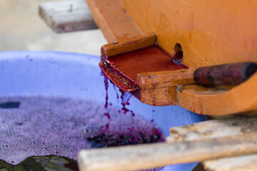Grape juice close up during the autumn harvest. Traditional old technique of wine making. Filtering grape must.