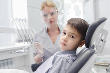 Obraz premium A child boy with a dentist in a dental office