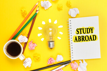 On a yellow background, a cup of coffee, a light bulb, pencils, a notebook with the inscription -...