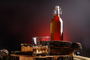 Ice cubes in a whiskey glass. Strong alcohol. Stand made of wood.