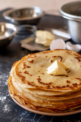a stack of pancakes and products for making pancakes - Russian traditional cuisine: milk, eggs, flour, butter.