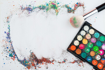 Makeup brushes on background with colorful powder. Make-up background