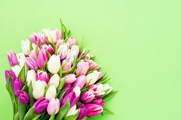 Pink tulips flowers bouquet on a bright green background. Valentine Day, Mothers day, Birthday celebration concept.