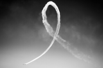 A plane paints a ribbon in the sky with smoke
