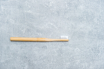 Bamboo toothbrush on grey background. Ecological and organic, zero waste concept