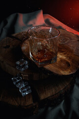 Old whiskey bottle on black wooden table. Drinks on a dark blurred background.