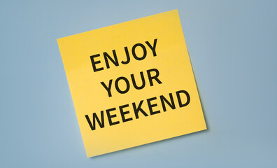 Enjoy The Weekend written on yellow stocker against blue background.