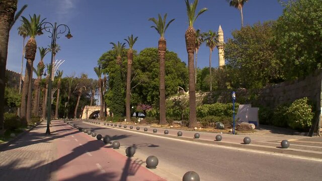 Kos Greece a beautifully landscaped road between historical monuments and palm trees