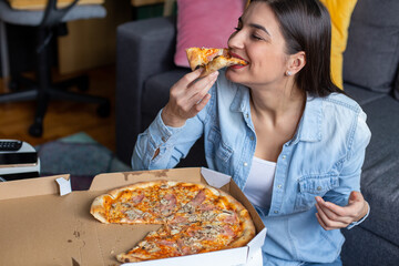 The woman is eating pizza at home and enjoying the taste. 