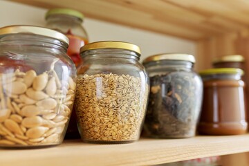 Kitchen pantry, wooden shelves with jars and containers with food, food storage.