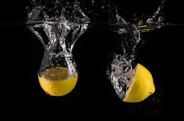 lemon falling into water black background