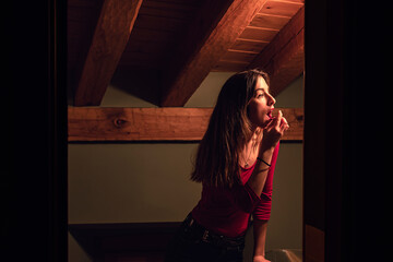 Woman putting on makeup in her room