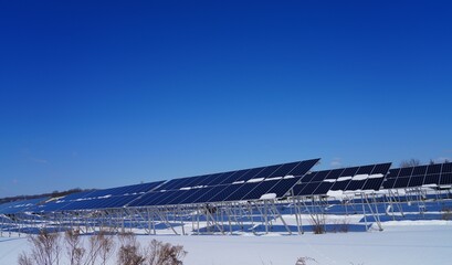 View of solar panels covered with snow at a solar farm in Montgomery, New Jersey, United States, after a snowfall.