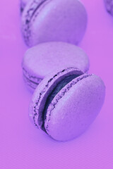 Colorful pink and purple macaron cookie filled with ganache cream