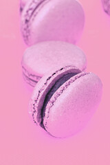 Colorful pink and purple macaron cookie filled with ganache cream