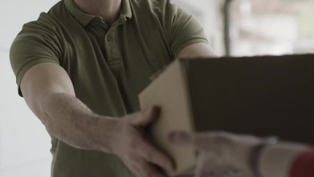 Close up of courier handing over a package
