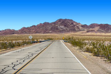 Route 66 in the Mojave Desert near Ludlow with a view of brown desert mountains