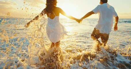 Happy couple in love, playing on the beach at sunset, running and splashing in the waves, travel vacation lifestyle. - Powered by Adobe