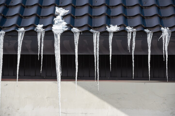 Icicles hanging down from metal pitched roof