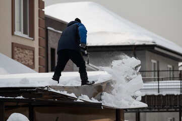 Man cleaning the roof from snow