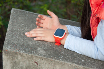 A girl wearing a orange smartwatch.