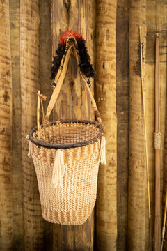 Modern luxury summer holiday or vacation beach house living room interior decoration. Indigenous style handcrafted braided straw basket hanging on rustic wooden wall.