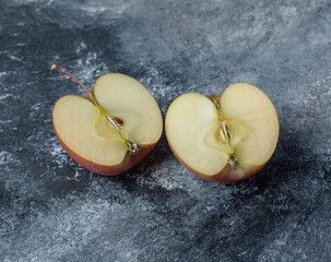 A sliced fresh red apple on marble background