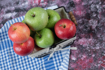 Fresh apples in a metallic basket covered with white towel