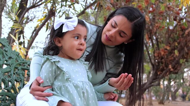 Madre da a hija un dulce en el parque