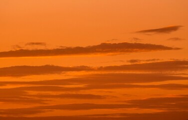 This image captures clouds floating through a warm sunset sky.